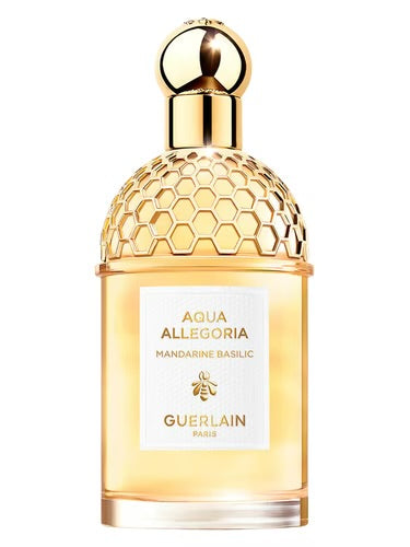Guerlain perfume bottle with gold cap and honeycomb design on a white background